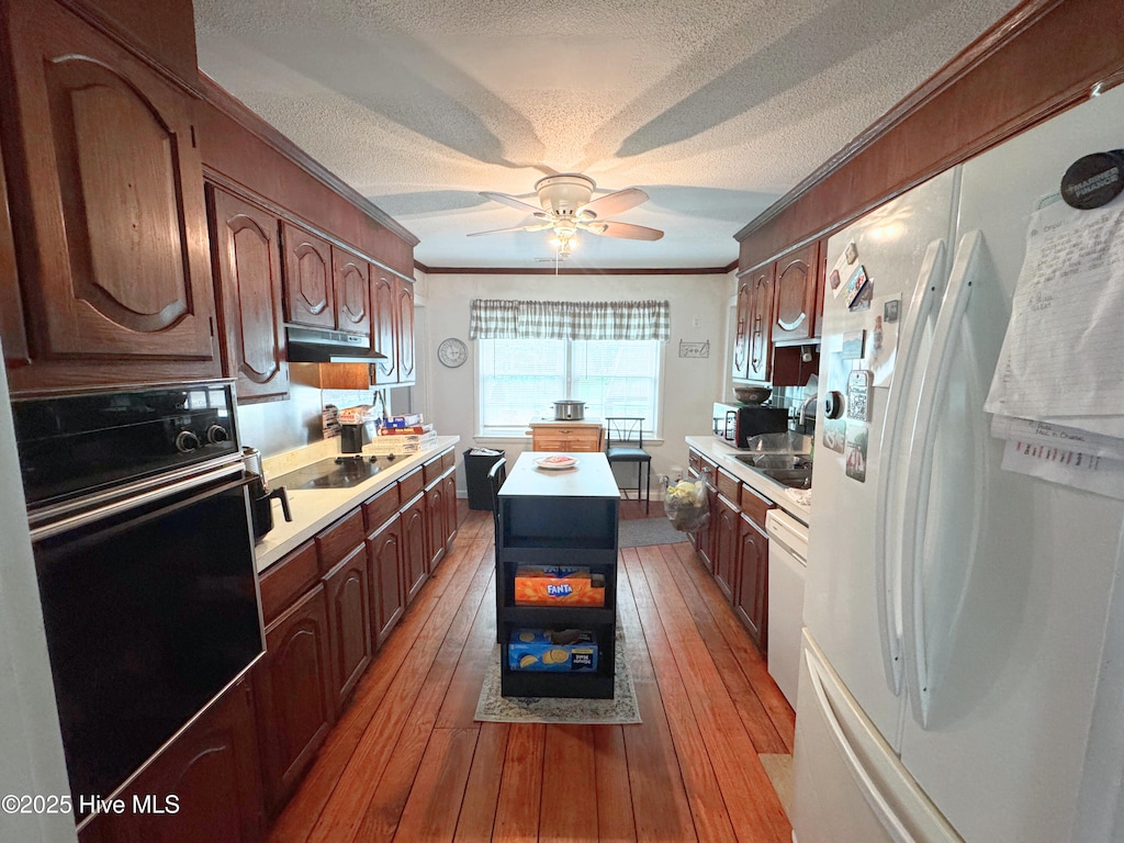 4321 Spearman Rd, Bolton, NC 28423 - kitchen featuring black appliances, a textured ceiling, light countertops, ornamental molding, and under cabinet range hood