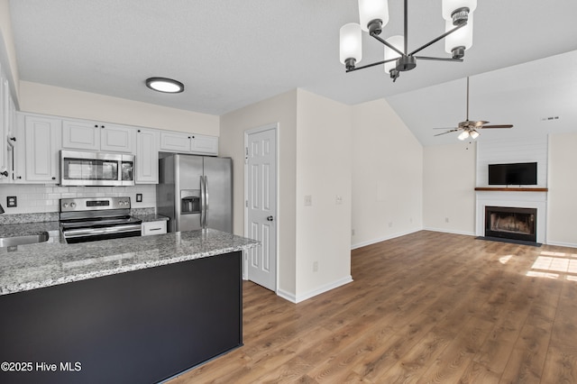 5601 W Chop Way, Wilmington, NC 28412 - kitchen featuring appliances with stainless steel finishes, a ceiling fan, white cabinetry, light stone counters, and a chandelier