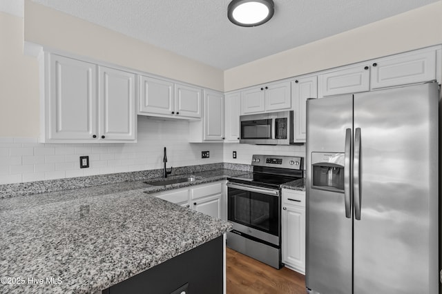 5601 W Chop Way, Wilmington, NC 28412 - kitchen featuring stainless steel appliances, white cabinetry, backsplash, and a textured ceiling