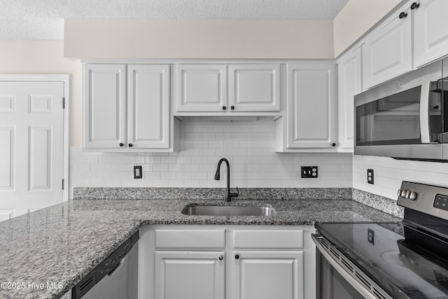 5601 W Chop Way, Wilmington, NC 28412 - kitchen with stainless steel appliances, a textured ceiling, white cabinetry, tasteful backsplash, and stone countertops