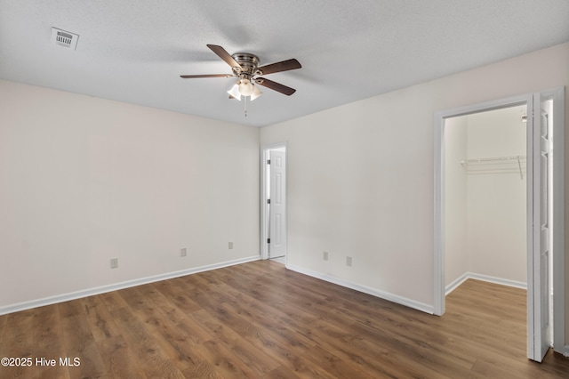 5601 W Chop Way, Wilmington, NC 28412 - unfurnished bedroom with wood finished floors, a spacious closet, a closet, and ceiling fan