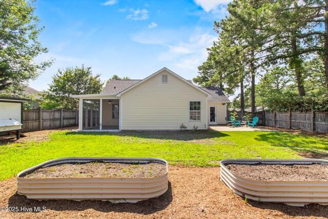 5601 W Chop Way, Wilmington, NC 28412 - back of property featuring a garden, a fenced backyard, a sunroom, a patio area, and roof with shingles