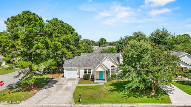 5601 W Chop Way, Wilmington, NC 28412 - view of front of home with concrete driveway, a garage, a front lawn, and view of wooded area