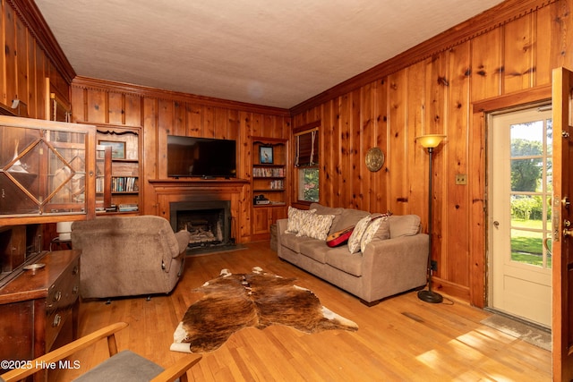 119 S Main St, Colerain, NC 27924 - living room featuring ornamental molding, wooden walls, a fireplace with flush hearth, and wood finished floors