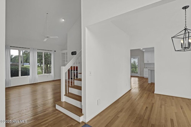 108 Sound View Dr, Hampstead, NC 28443 - staircase featuring high vaulted ceiling, a chandelier, wood finished floors, a ceiling fan, and recessed lighting