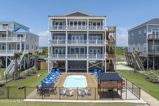1326 New River Inlet Rd, North Topsail Beach, NC 28460 - back of property featuring a fenced backyard, a balcony, a garage, stairway, and a patio area