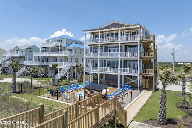 1326 New River Inlet Rd, North Topsail Beach, NC 28460 - view of apartment building / complex featuring stairs, a fenced backyard, and an outdoor pool
