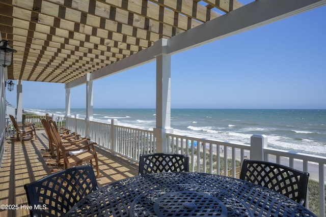 1326 New River Inlet Rd, North Topsail Beach, NC 28460 - deck with outdoor dining area, a pergola, and view of water and beach