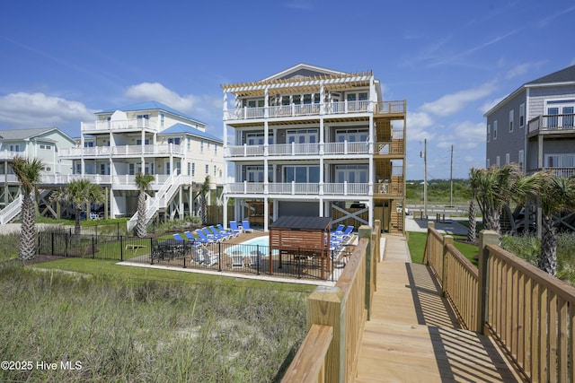 1326 New River Inlet Rd, North Topsail Beach, NC 28460 - rear view of property featuring a balcony, a community pool, stairs, and a patio area