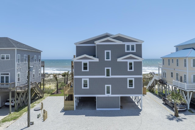 1326 New River Inlet Rd, North Topsail Beach, NC 28460 - back of property with stairs, view of water and beach, a carport, and driveway