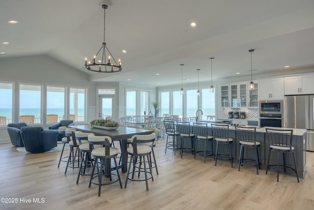 1326 New River Inlet Rd, North Topsail Beach, NC 28460 - dining room with light wood-style floors, a chandelier, recessed lighting, and lofted ceiling