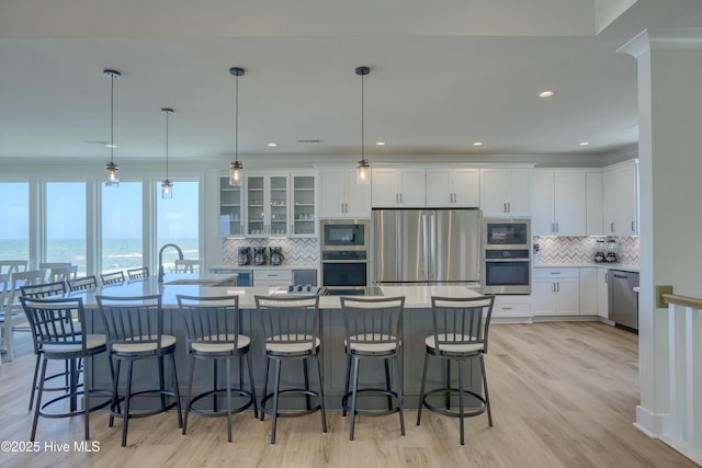 1326 New River Inlet Rd, North Topsail Beach, NC 28460 - kitchen with stainless steel appliances, backsplash, white cabinetry, a kitchen breakfast bar, and recessed lighting