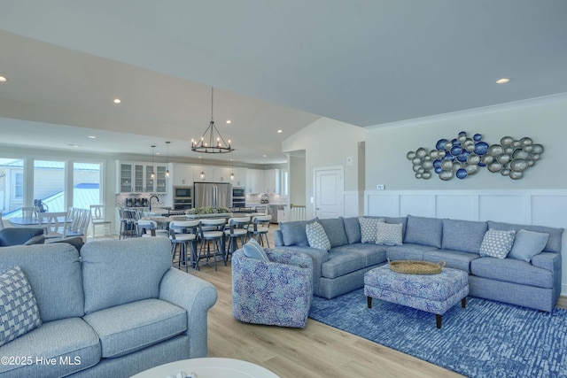 1326 New River Inlet Rd, North Topsail Beach, NC 28460 - living area with a chandelier, light wood-style floors, recessed lighting, wainscoting, and a decorative wall