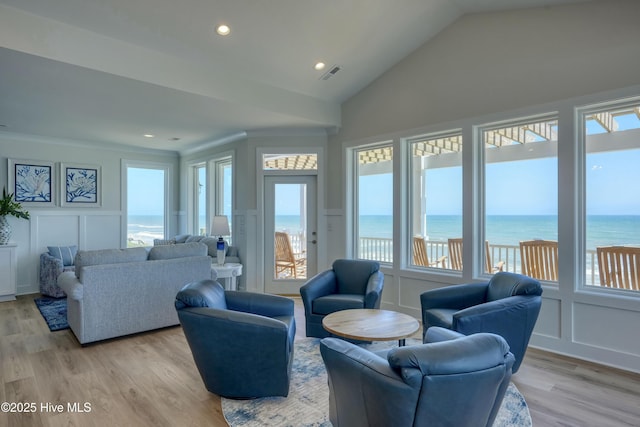 1326 New River Inlet Rd, North Topsail Beach, NC 28460 - living area with a decorative wall, plenty of natural light, light wood finished floors, a water view, and vaulted ceiling