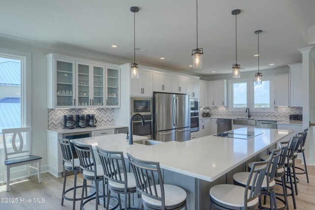 1326 New River Inlet Rd, North Topsail Beach, NC 28460 - kitchen featuring stainless steel appliances, decorative backsplash, a spacious island, light wood-type flooring, and recessed lighting