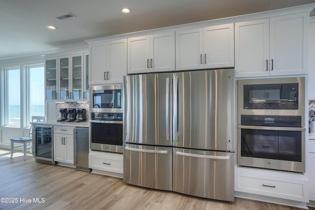 1326 New River Inlet Rd, North Topsail Beach, NC 28460 - kitchen with stainless steel appliances, wine cooler, backsplash, recessed lighting, and glass insert cabinets