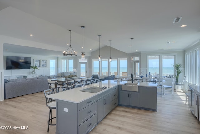 1326 New River Inlet Rd, North Topsail Beach, NC 28460 - kitchen featuring gray cabinets, a breakfast bar area, light countertops, light wood-type flooring, and recessed lighting
