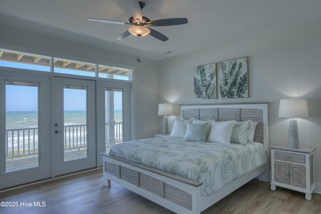 1326 New River Inlet Rd, North Topsail Beach, NC 28460 - bedroom featuring access to outside, wood finished floors, french doors, a water view, and a ceiling fan