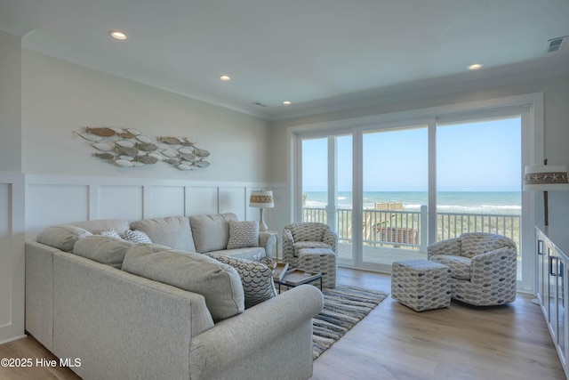 1326 New River Inlet Rd, North Topsail Beach, NC 28460 - living area featuring wood finished floors, view of water and beach, a decorative wall, a wainscoted wall, and recessed lighting