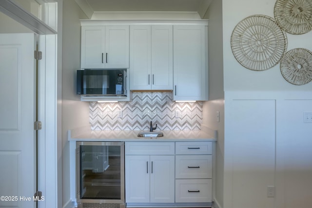 1326 New River Inlet Rd, North Topsail Beach, NC 28460 - kitchen featuring beverage cooler, black microwave, tasteful backsplash, light countertops, and white cabinets