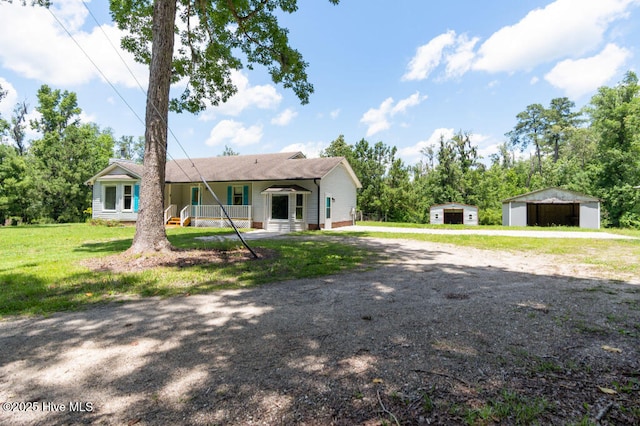 5025 NC Highway 55 E, New Bern, NC 28560 - back of house featuring a detached garage, an outdoor structure, a lawn, dirt driveway, and covered porch
