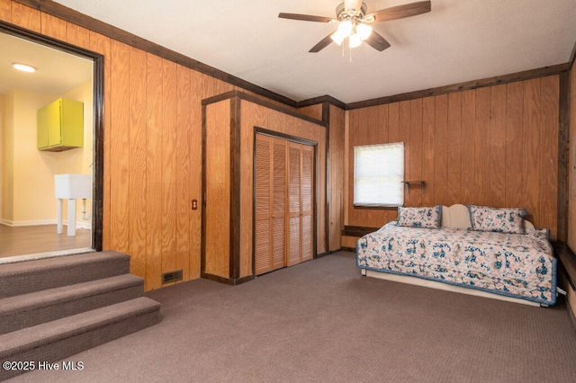 5025 NC Highway 55 E, New Bern, NC 28560 - carpeted bedroom featuring wooden walls, ornamental molding, a closet, and ceiling fan