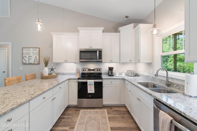 109 SW 17th St, Oak Island, NC 28465 - kitchen featuring stainless steel appliances, white cabinets, light wood-style floors, light stone countertops, and decorative light fixtures