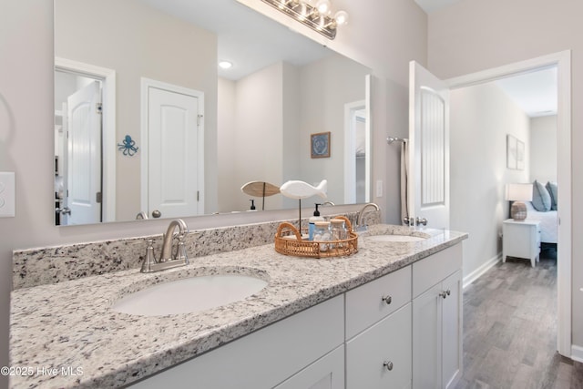 109 SW 17th St, Oak Island, NC 28465 - bathroom featuring double vanity, wood finished floors, and ensuite bathroom
