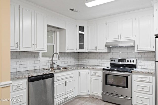 383 Red Fox St NW, Shallotte, NC 28470 - kitchen featuring appliances with stainless steel finishes, under cabinet range hood, white cabinetry, and light stone countertops