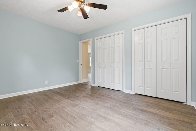 383 Red Fox St NW, Shallotte, NC 28470 - unfurnished bedroom featuring wood finished floors, two closets, and ceiling fan