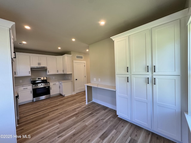 317 Whitfield Dr, Goldsboro, NC 27530 - kitchen featuring stainless steel range with electric stovetop, wood finished floors, white cabinetry, recessed lighting, and light countertops