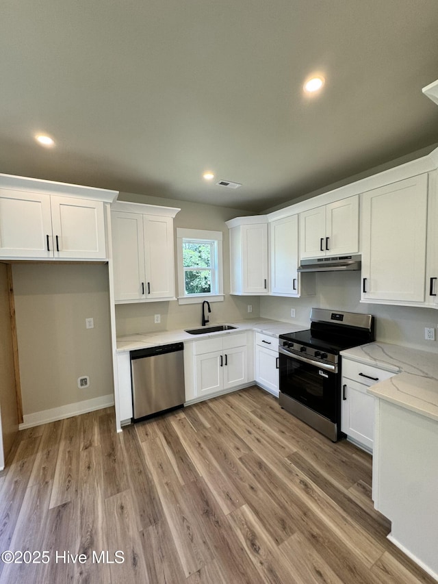 317 Whitfield Dr, Goldsboro, NC 27530 - kitchen with stainless steel appliances, under cabinet range hood, white cabinetry, light wood finished floors, and recessed lighting