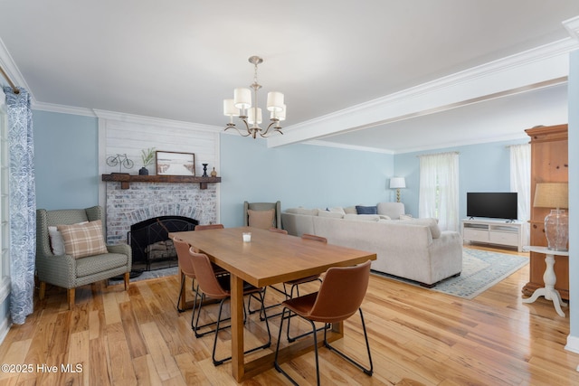 429 Tanbridge Rd, Wilmington, NC 28405 - dining room featuring a fireplace, light wood-style floors, a chandelier, and crown molding