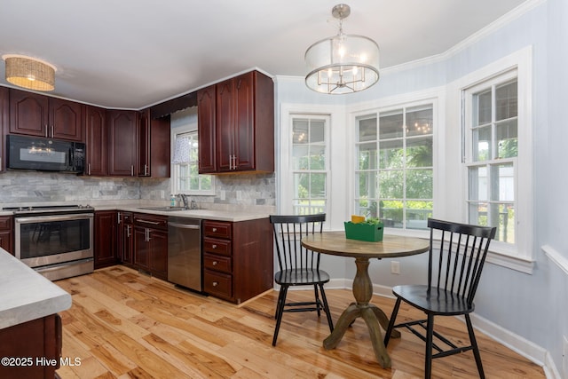 429 Tanbridge Rd, Wilmington, NC 28405 - kitchen featuring stainless steel appliances, light countertops, light wood-type flooring, tasteful backsplash, and ornamental molding