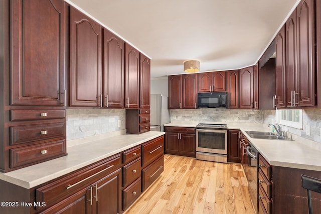 429 Tanbridge Rd, Wilmington, NC 28405 - kitchen with appliances with stainless steel finishes, light countertops, light wood finished floors, and decorative backsplash