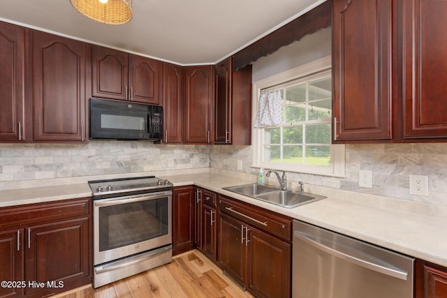 429 Tanbridge Rd, Wilmington, NC 28405 - kitchen featuring appliances with stainless steel finishes, light countertops, light wood finished floors, and decorative backsplash
