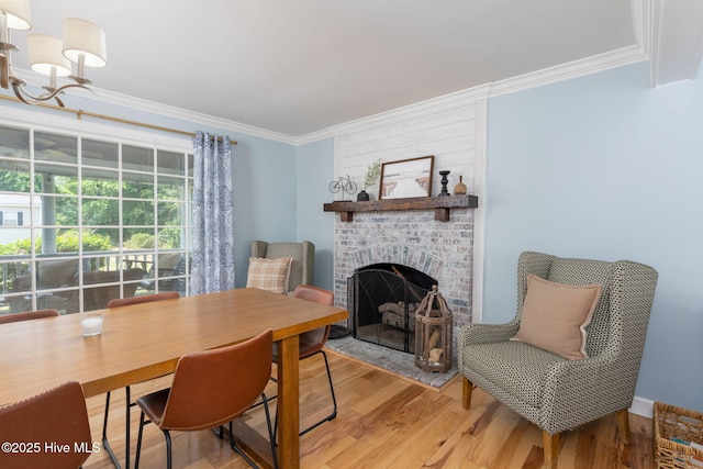 429 Tanbridge Rd, Wilmington, NC 28405 - dining room featuring crown molding, light wood-style floors, a brick fireplace, and a chandelier