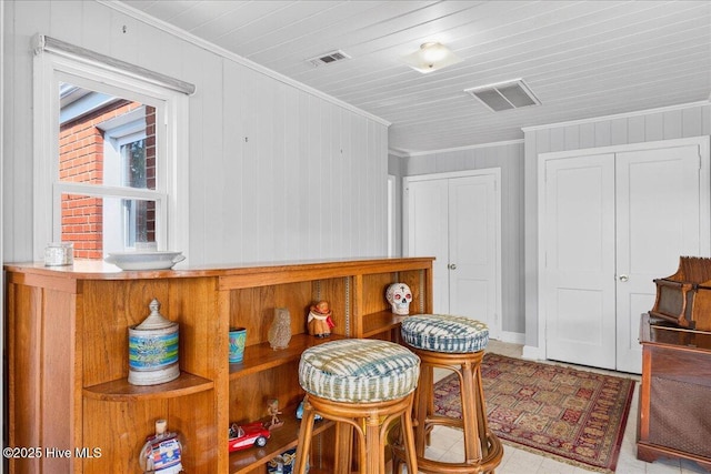 living area featuring ornamental molding and wood walls