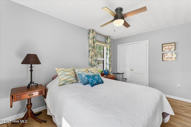 bedroom with a closet, a ceiling fan, and wood finished floors