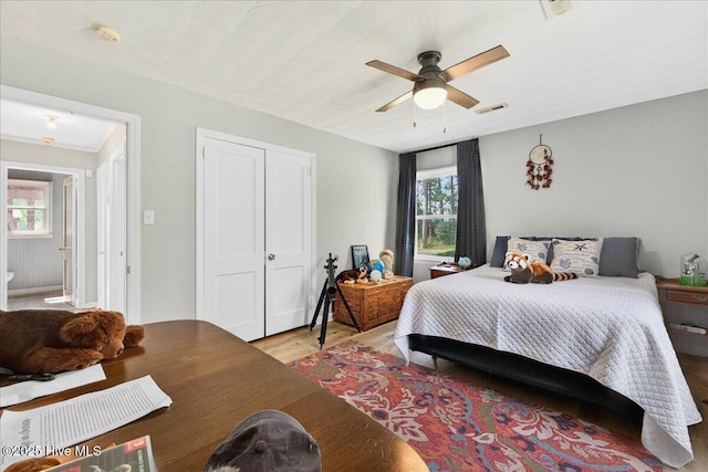 bedroom featuring light wood-type flooring, a ceiling fan, and a closet