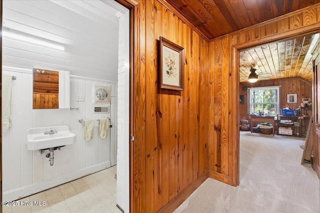 hallway with wooden walls, wooden ceiling, and vaulted ceiling