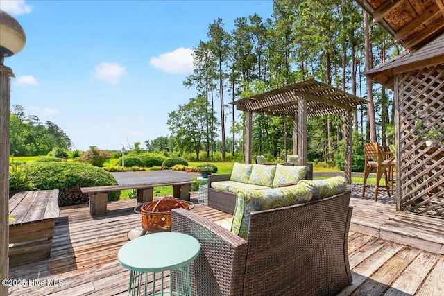 wooden deck featuring an outdoor living space with a fire pit