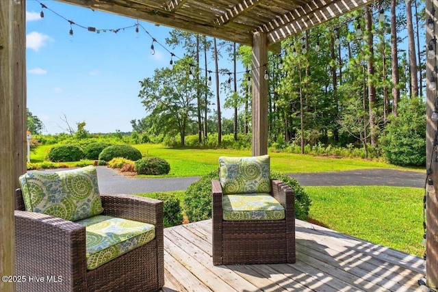 wooden terrace featuring a yard and a pergola