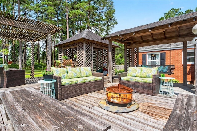 wooden terrace featuring a gazebo, an outdoor living space with a fire pit, and a pergola