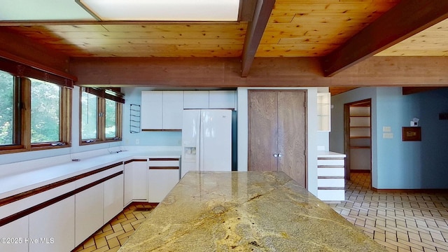 1402 Green Springs Rd, New Bern, NC 28560 - kitchen with white fridge with ice dispenser, brick patterned floors, white cabinetry, and a wood ceiling with exposed beams