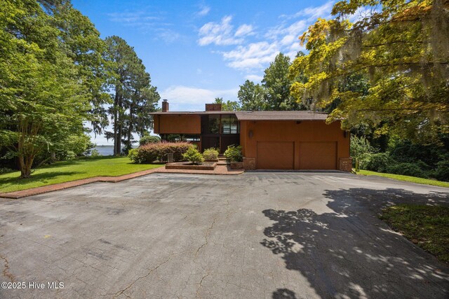 1402 Green Springs Rd, New Bern, NC 28560 - view of front facade with a front yard, a garage, asphalt driveway, and a chimney