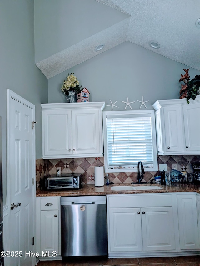 7 Oleander Ln, Ocean Isle Beach, NC 28469 - kitchen with dishwasher, vaulted ceiling, tasteful backsplash, and white cabinetry