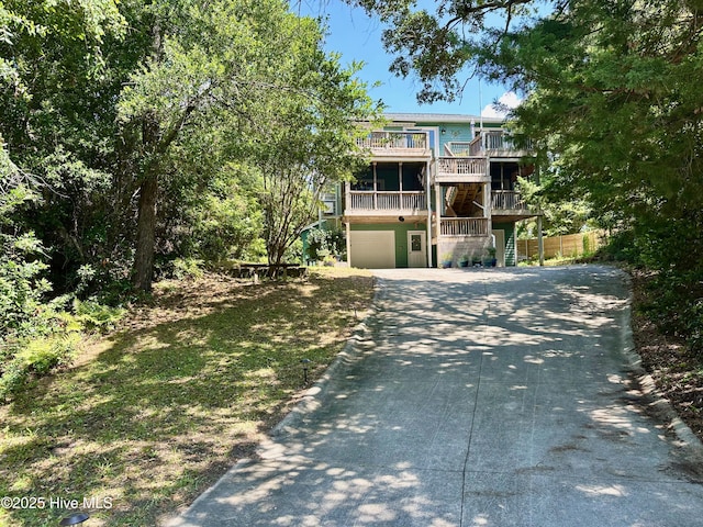 122 Ethel Dr, Emerald Isle, NC 28594 - view of front facade with driveway, an attached garage, stairway, and a balcony