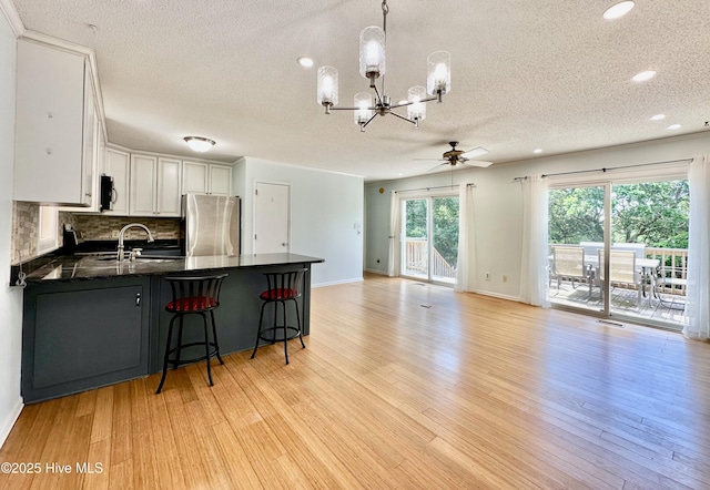 122 Ethel Dr, Emerald Isle, NC 28594 - kitchen featuring freestanding refrigerator, a chandelier, ceiling fan, a textured ceiling, and white cabinetry