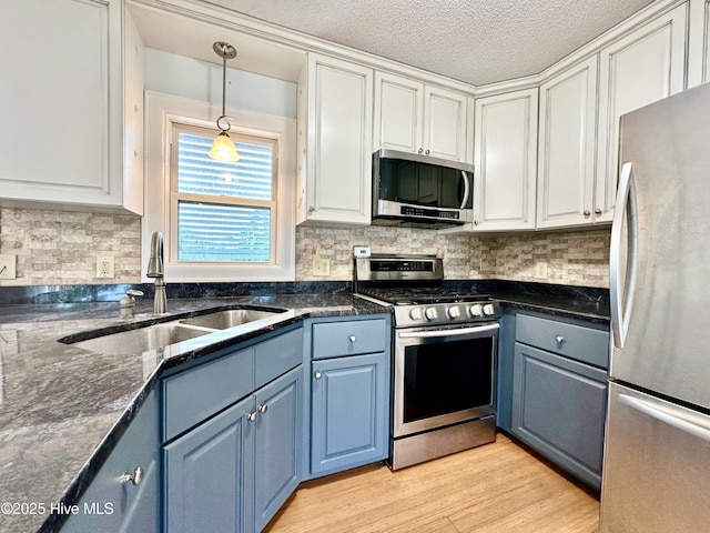 122 Ethel Dr, Emerald Isle, NC 28594 - kitchen with appliances with stainless steel finishes, blue cabinetry, white cabinetry, pendant lighting, and a textured ceiling